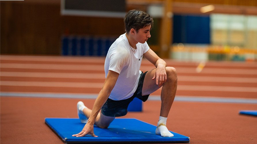 Gabriel Wallmark strechar p� en matta. 